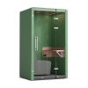 Green telephone booth with a glass door and sofa